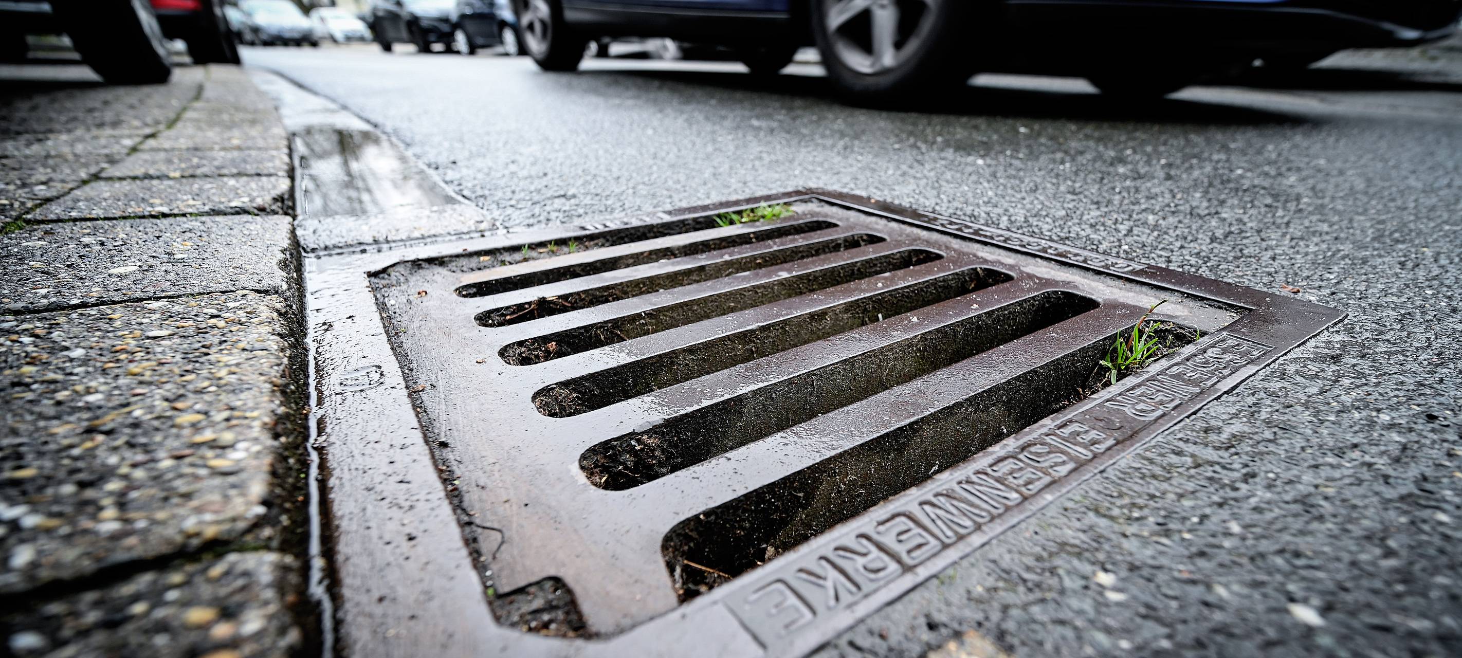 Ein Gullydeckel an einer Straße
