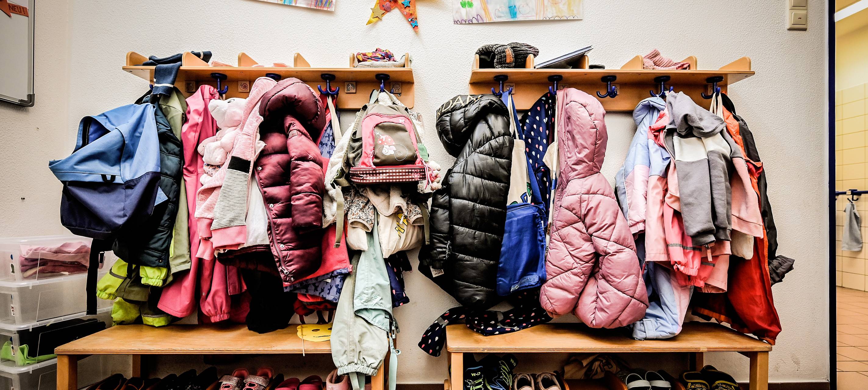 Kinderjacken hängen in einer Kita am Haken