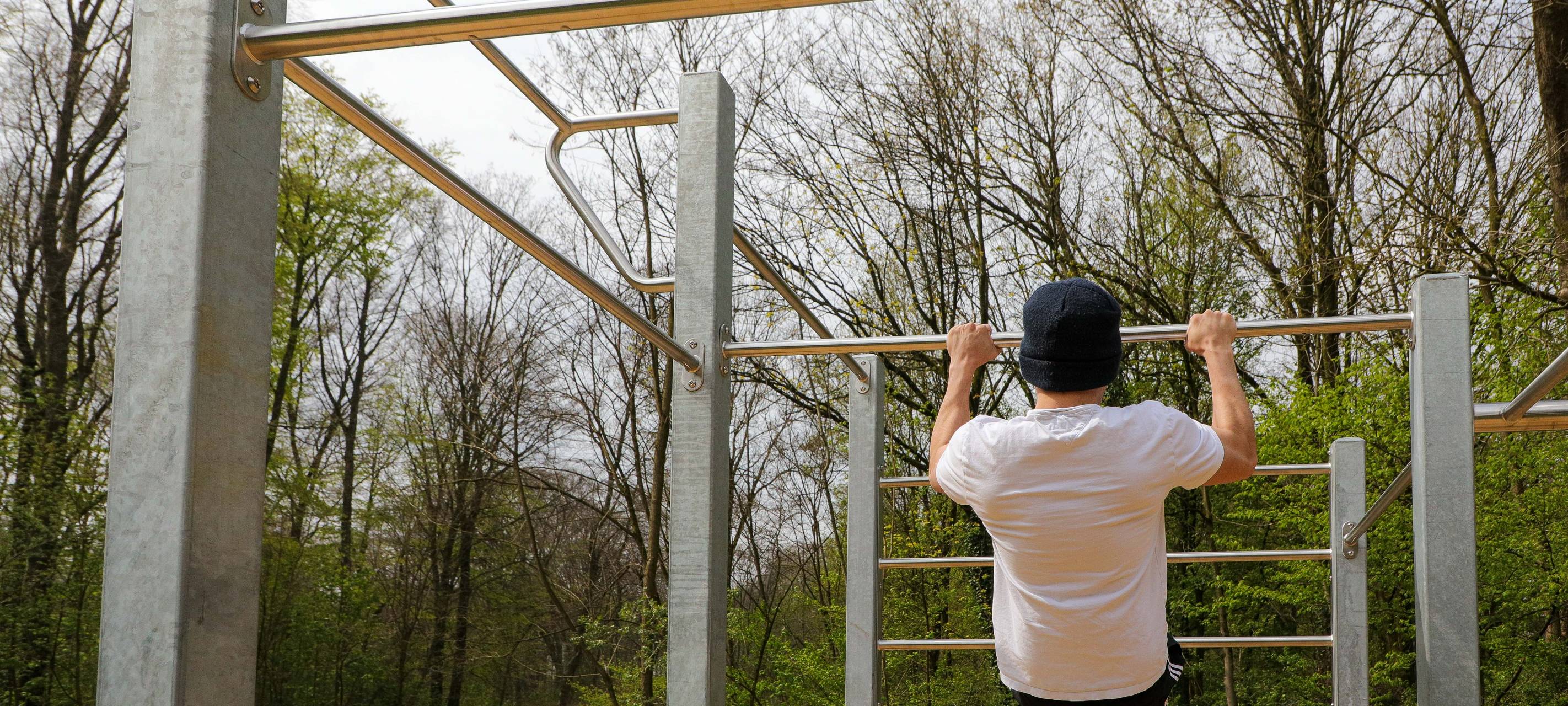 Sportler an einer Calisthenics-Anlage
