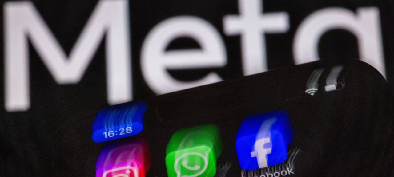 Die Apps Instagram, Facebook und WhatsApp sind auf dem Display eines Smartphones vor dem Logo des Internetkonzerns Meta zu sehen
