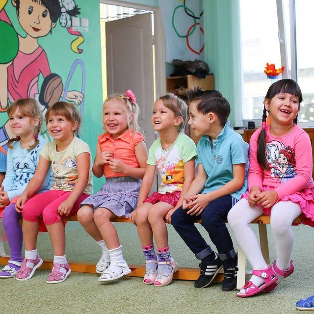 Eine Gruppe Kleinkinder sitzen in einem Kindergarten-Kreis