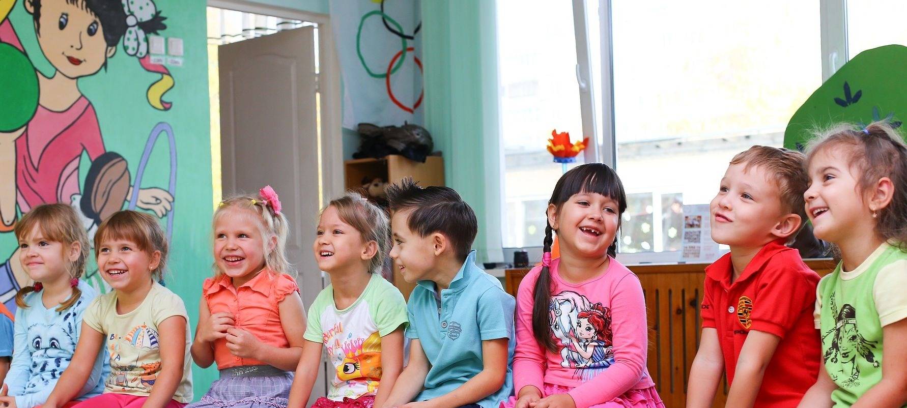 Eine Gruppe Kleinkinder sitzen in einem Kindergarten-Kreis