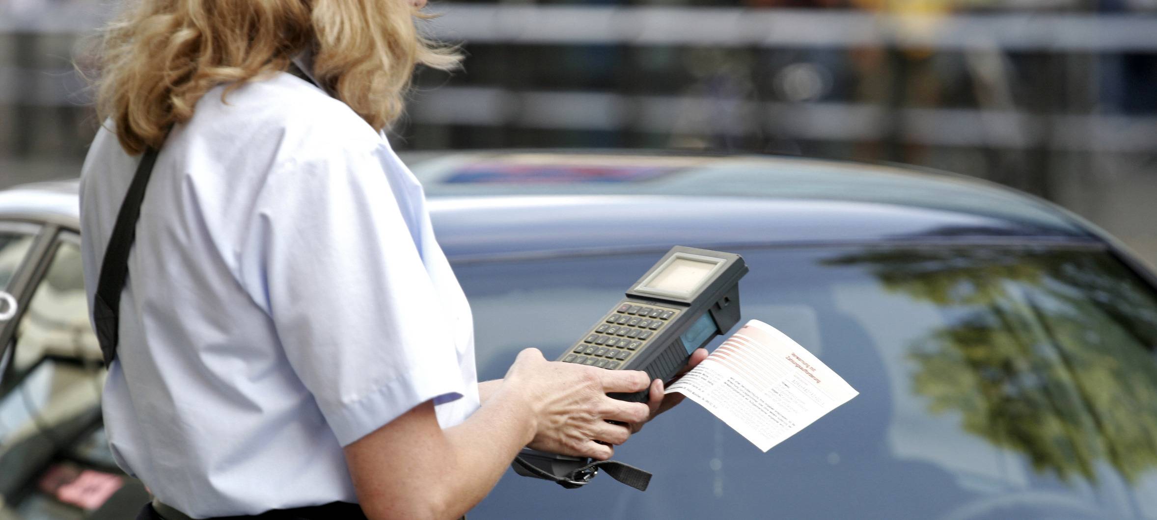 Symbolbild einer Politesse, die einen Strafzettel ausstellt